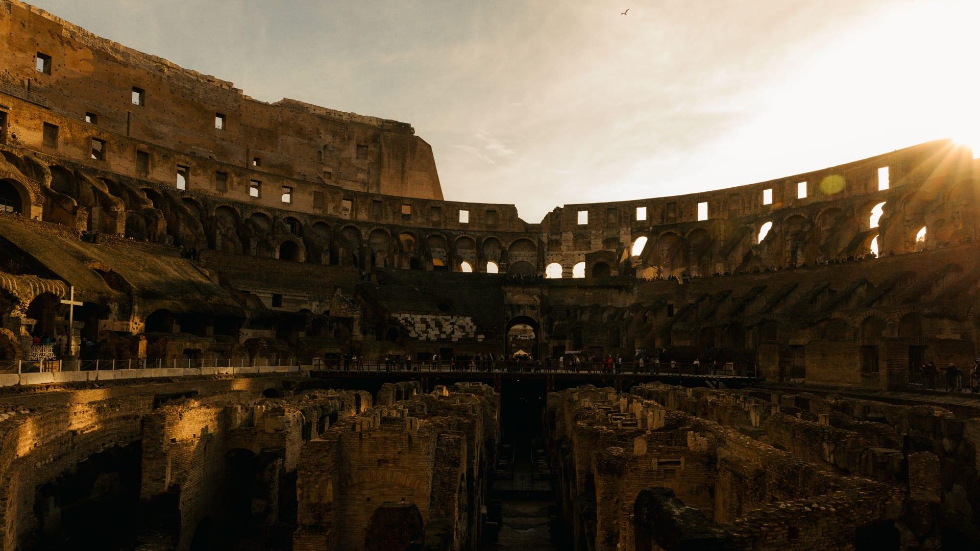 The interior of the Roman Colosseum lit by golden sunset light