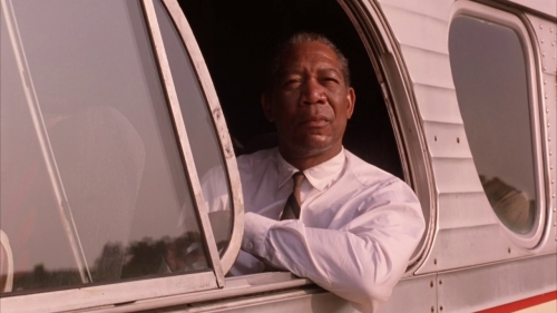 Red looks out the bus window on his way to freedom